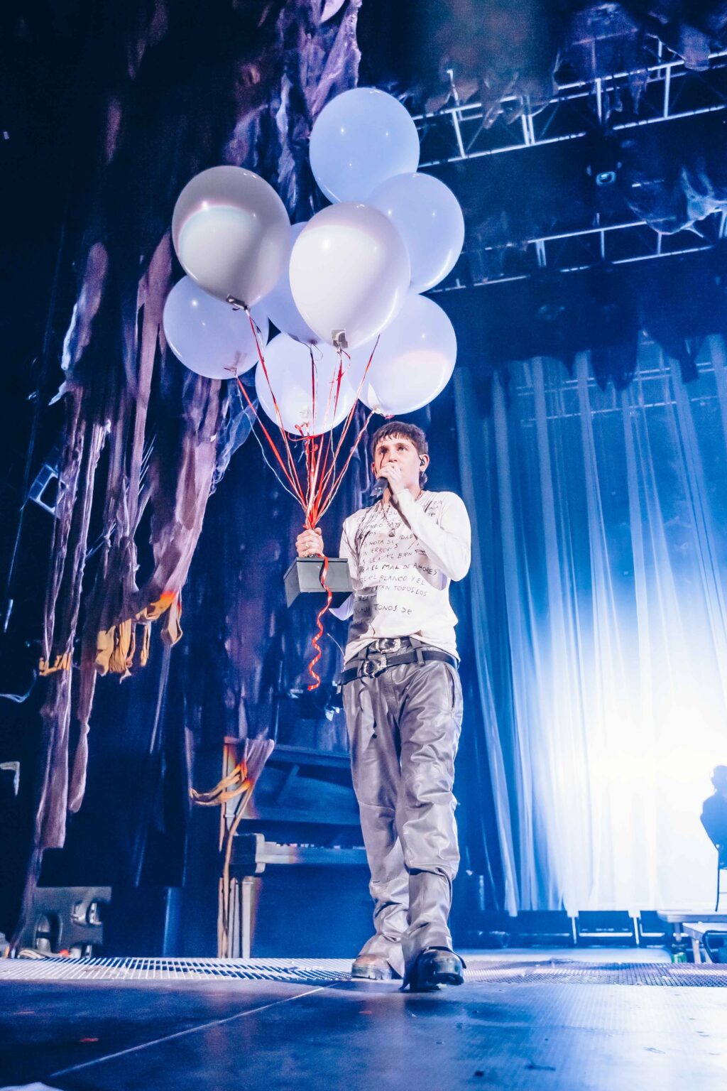 Dillom on stage holding a bunch of white balloons — Dillom at Estadio Luna Park, Buenos Aires, 19 June 2024. Photographed by Anita Almaraz.
