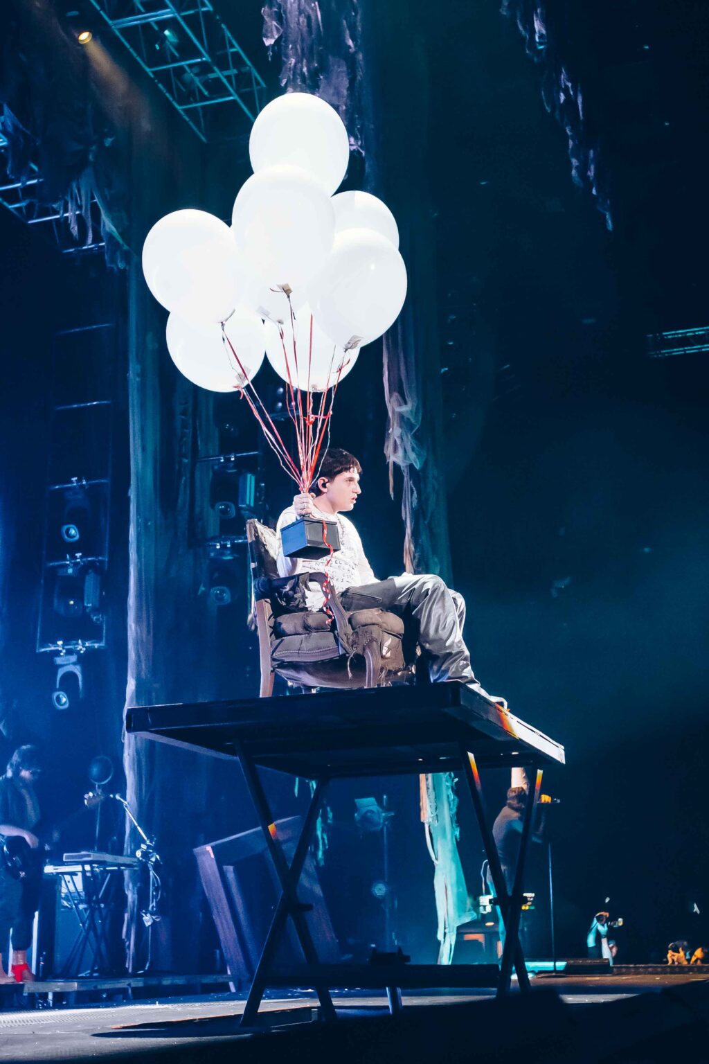 Dillom in the chair with the balloons, seen wide — Dillom at Estadio Luna Park, Buenos Aires, 19 June 2024. Photographed by Anita Almaraz.